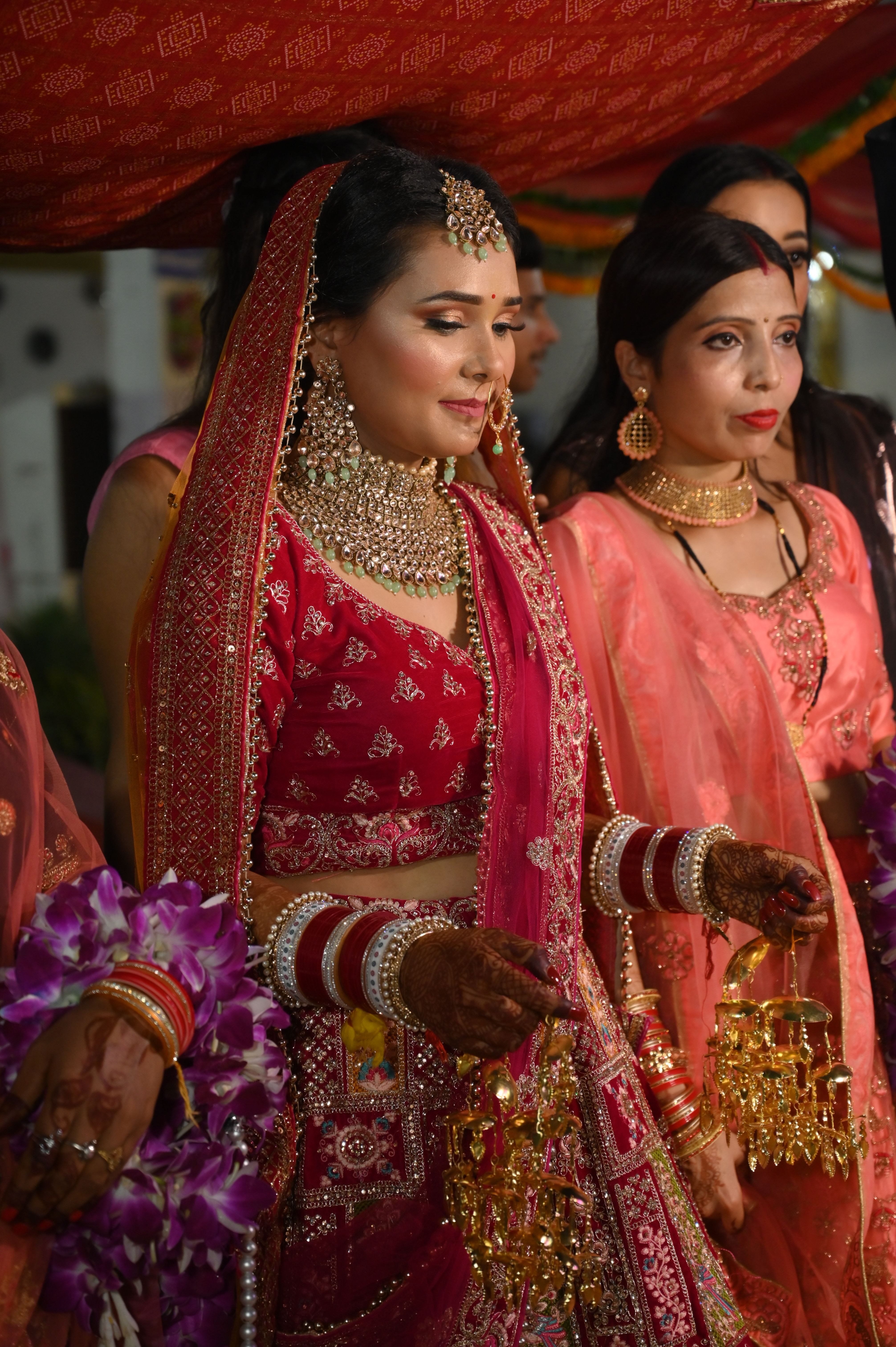 An elegant Indian bride wearing a traditional red lehenga at her wedding ceremony.