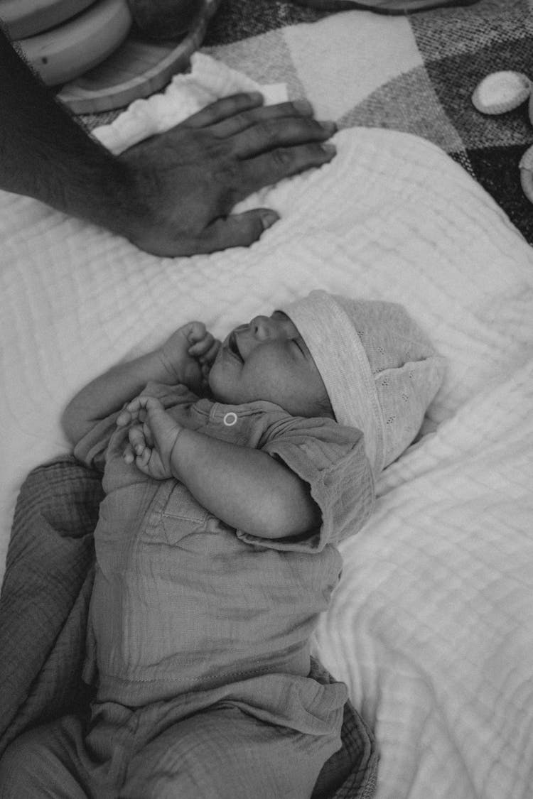 Father Hand Near Sleeping Baby In Black And White