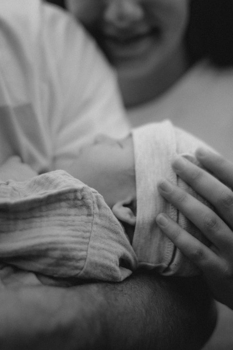 Parent Hand Holding Sleeping Baby