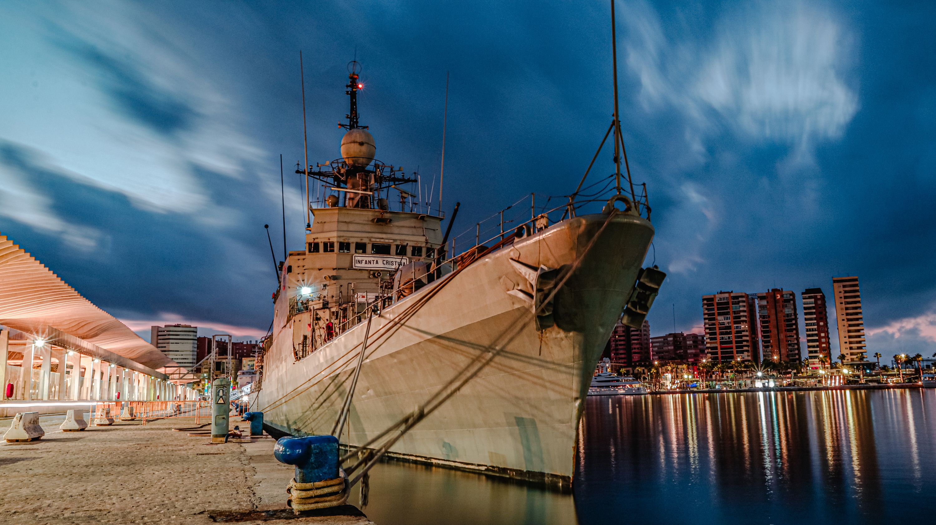 Night view of a ship docked in the vibrant Málaga harbor, capturing the city's dynamic waterfront. - Málaga