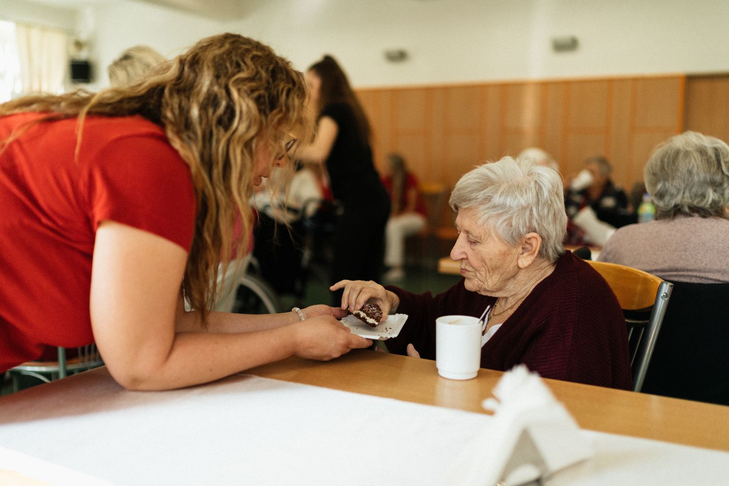 Caregiver assisting elderly residents with daily activities in a cozy care home