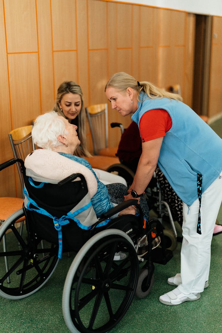 Caregiver Talking To An Elderly Woman On A Wheelchair