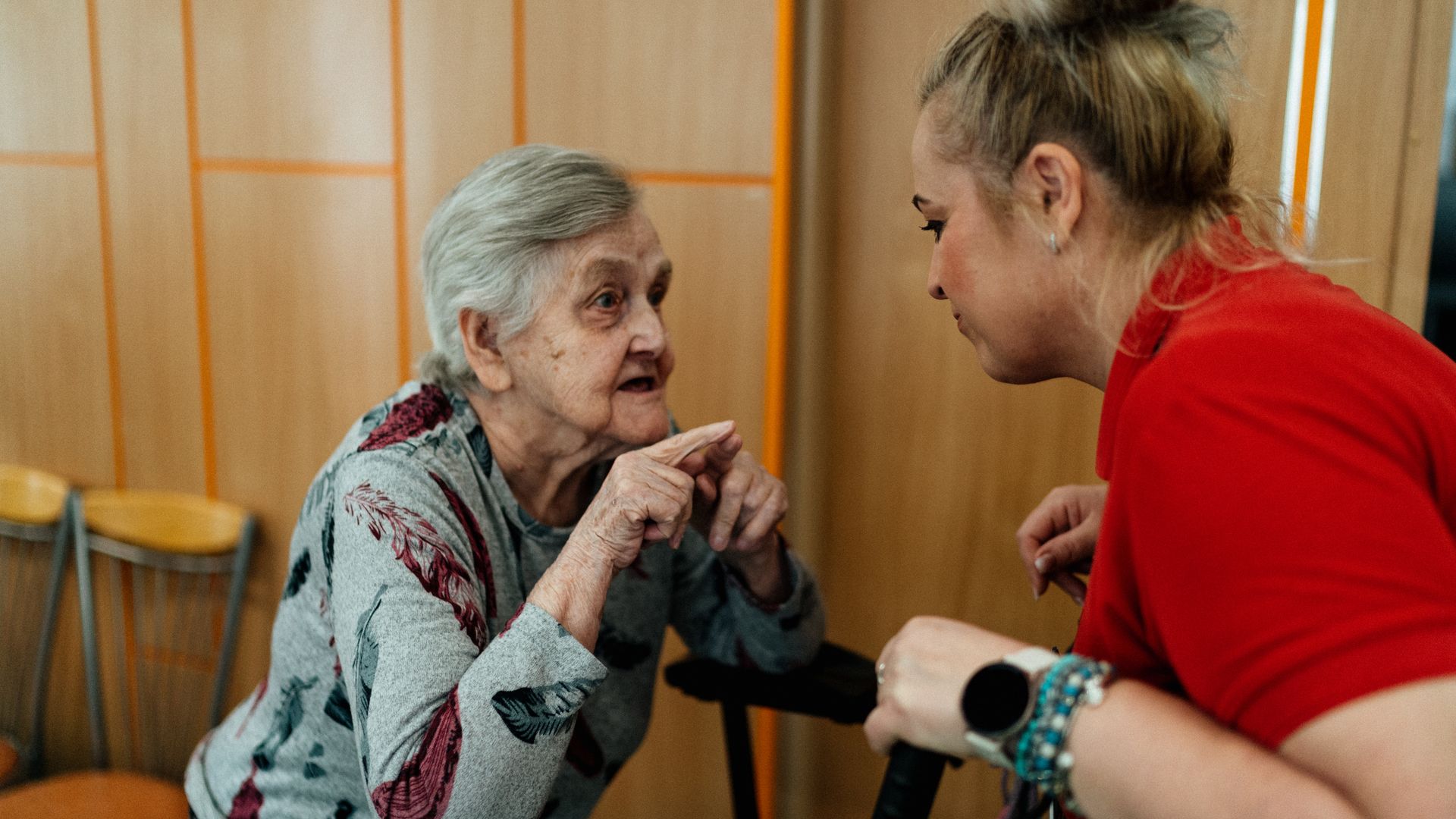 Caregiver in conversation with an elderly woman, representing social care
