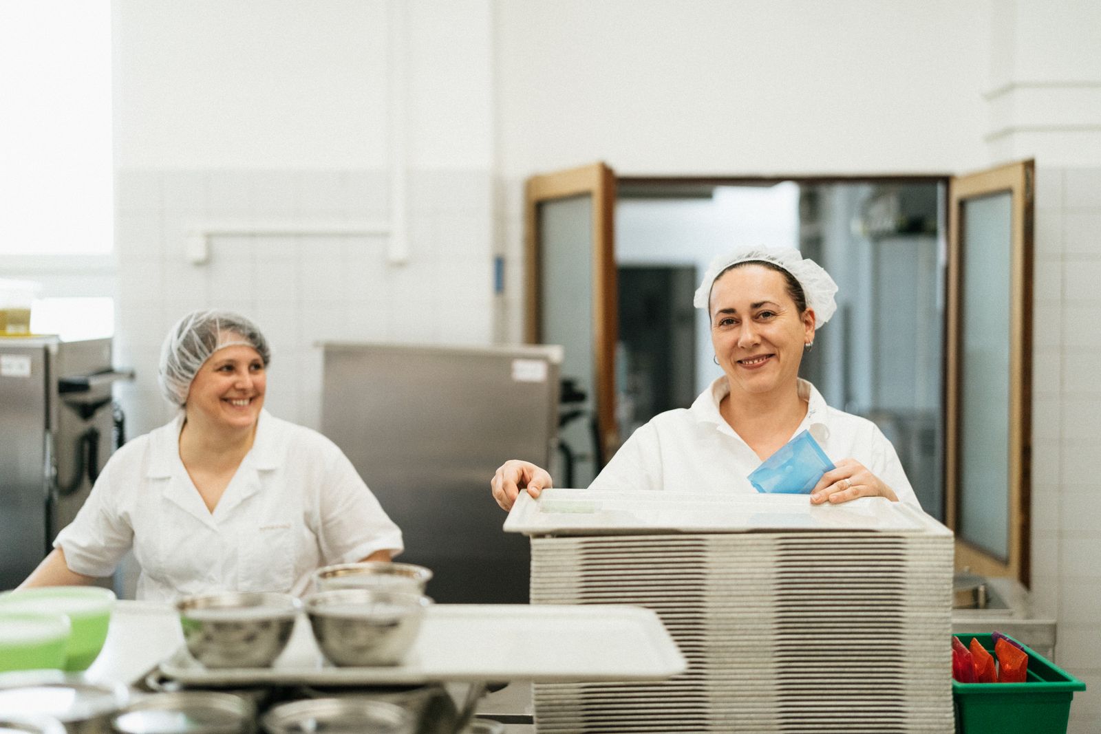 Equipe de cozinha uniformizada trabalhando no refeitório de uma empresa