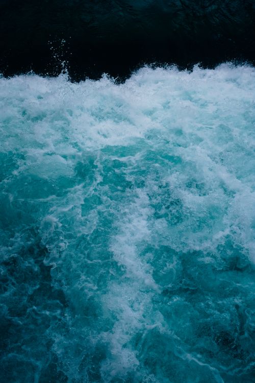 Free Close-up view of ocean waves crashing and forming sea foam, capturing the power of nature. Stock Photo