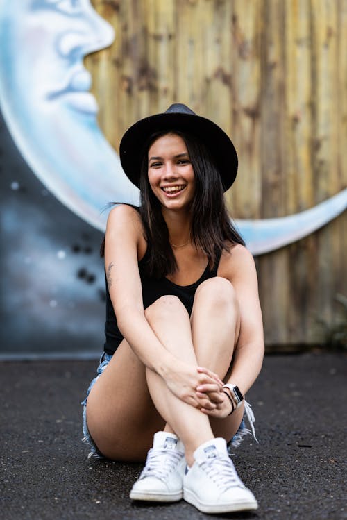 Smiling Young Woman Sitting on the Street