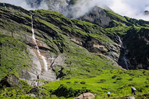 Free A picturesque waterfall cascading down a lush green mountainside, perfect for nature and travel enthusiasts. Stock Photo
