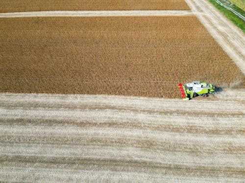 Aerial Photo of a Green Combine Harverster Working in a Crop Field