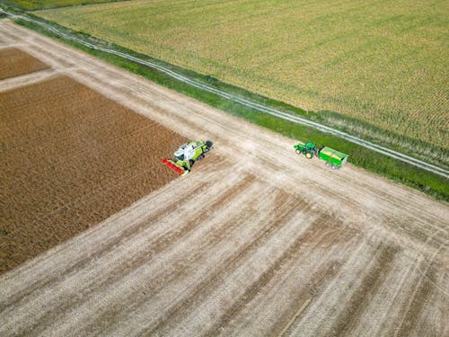 Aerial View of a Combine Harvester and a Tractor on a Crop