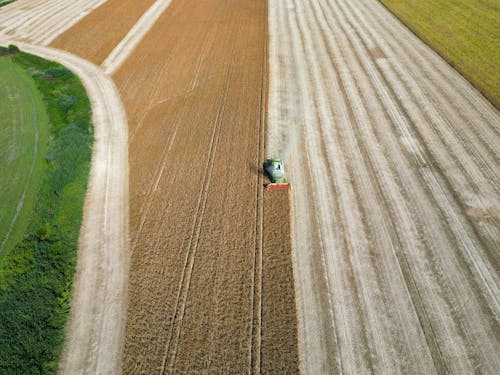 Free Drone Shot of a Combine Harvester on a Cropland  Stock Photo