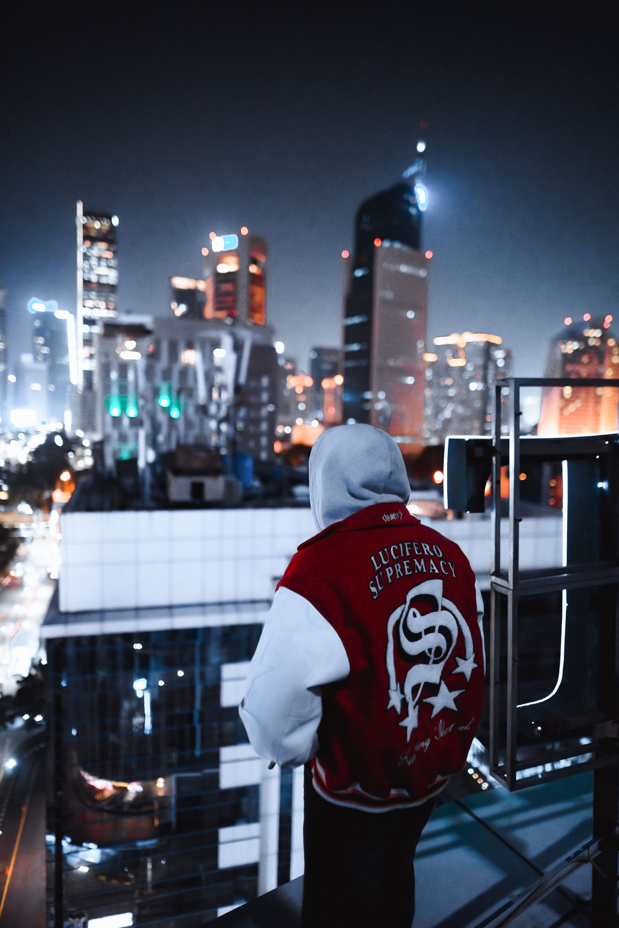 Persona con hoodie frente a ciudad iluminada
