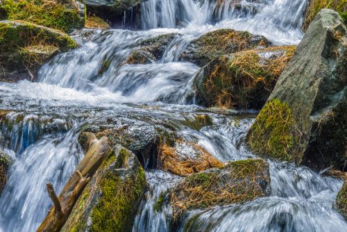 Free Peaceful waterfall flowing over moss-covered rocks, capturing natural beauty and tranquility. Stock Photo