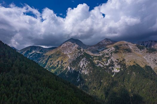 A vast mountain range with dark clouds creates a dramatic and scenic view, capturing the beauty of nature.