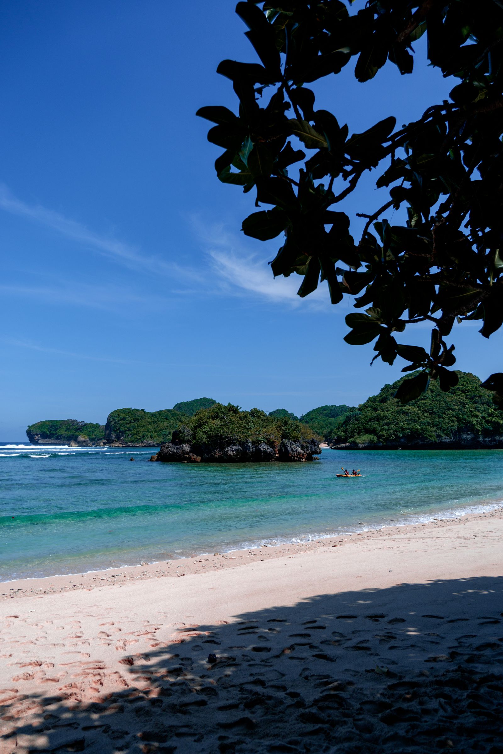เรือคายักล่องผ่านน้ำใสข้างเกาะเขียวในทะเลเขตร้อน