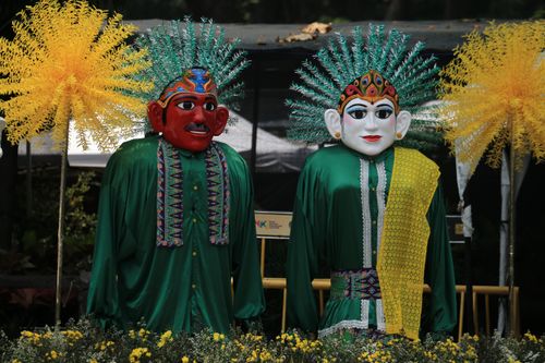 Free Colorful ondel-ondel puppets wearing traditional costumes at an outdoor festival. Stock Photo
