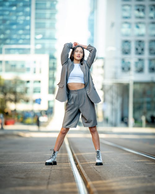 Woman in Gray Blazer and Shorts Posing on a Road