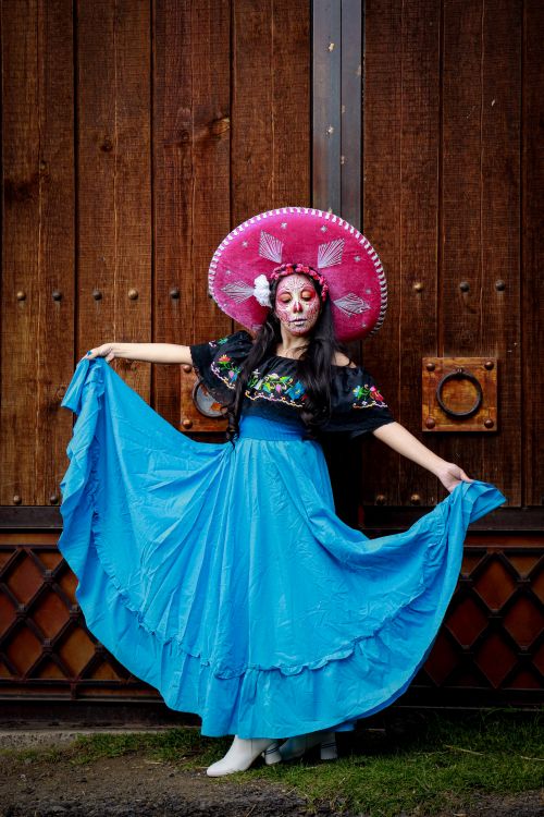Free Mexican woman in traditional Day of the Dead attire with skull makeup, vivid colors. Stock Photo