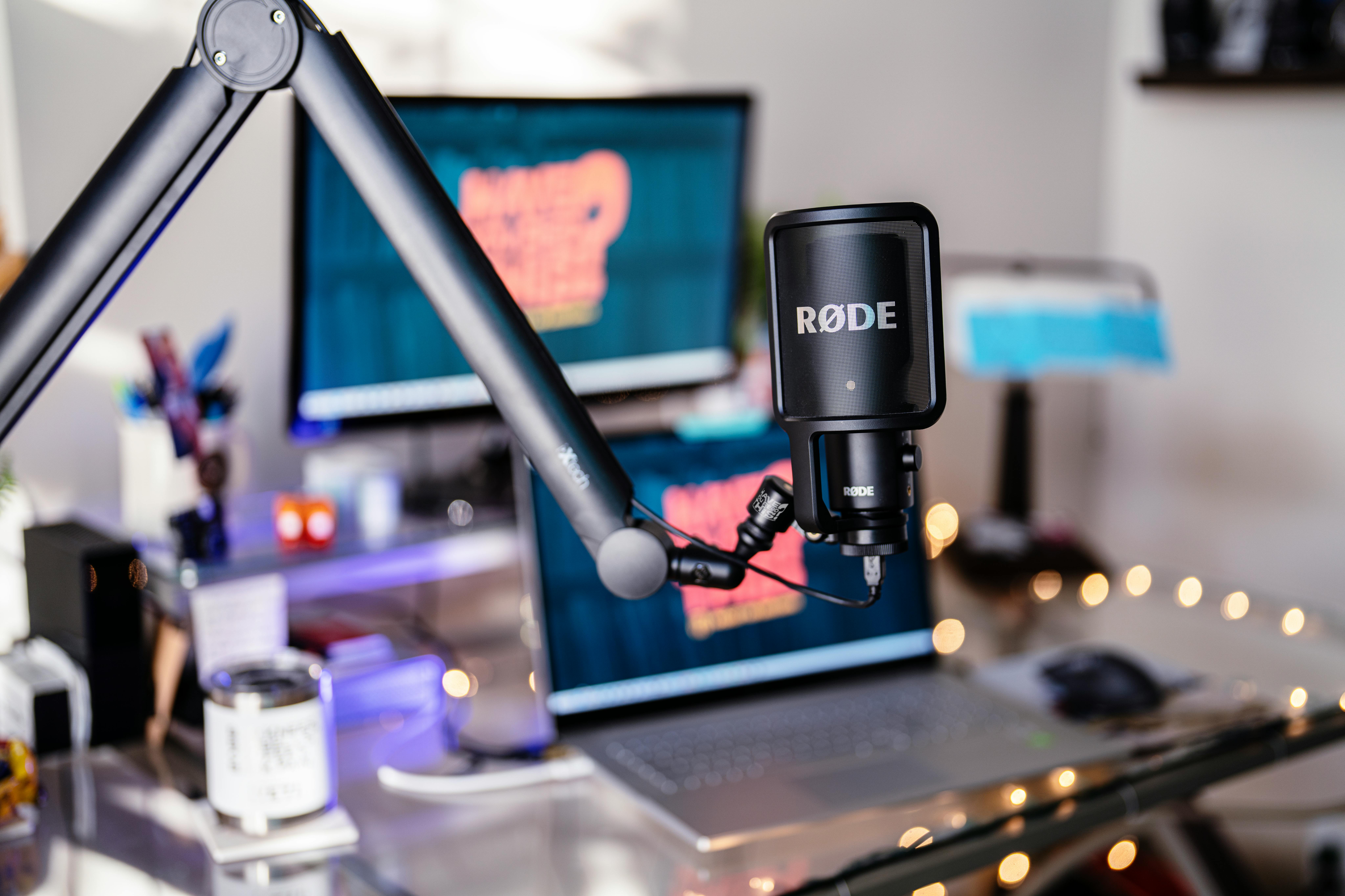 Close-up of a modern podcast studio featuring a RØDE microphone and digital workspace, ideal for content creators.