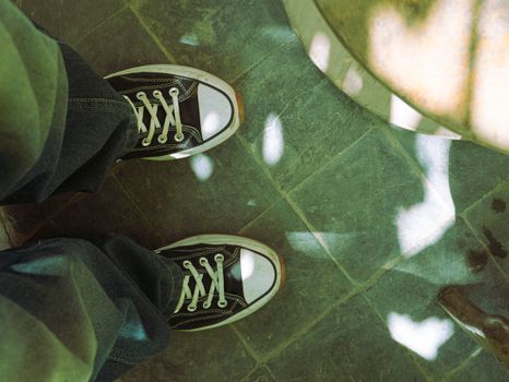 Top view of vintage sneakers on a sunlit pavement, embodying a retro vibe.