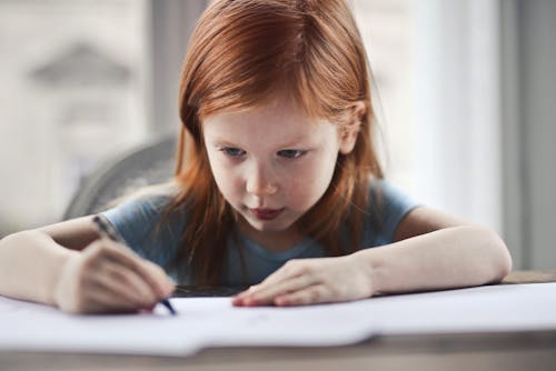 Девушка пишет на бумаге