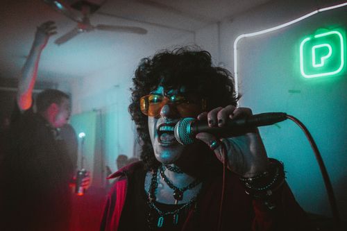Free Capture of a dynamic karaoke performance at a lively indoor party, with neon lights and crowd interaction. Stock Photo