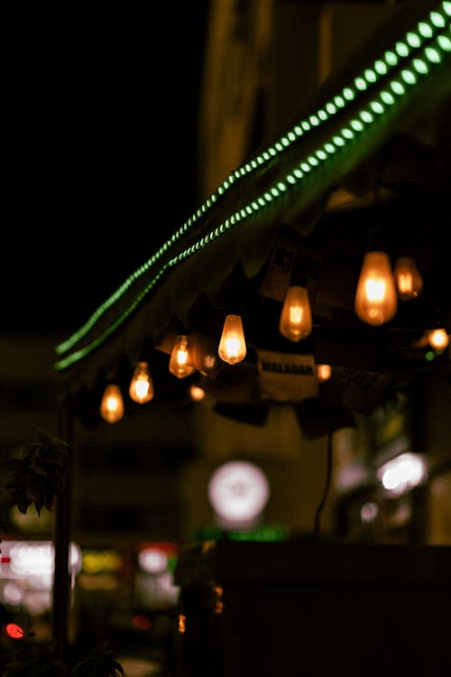 Close-up of String Lights with Light Bulbs Hanging Outside of a Building 
