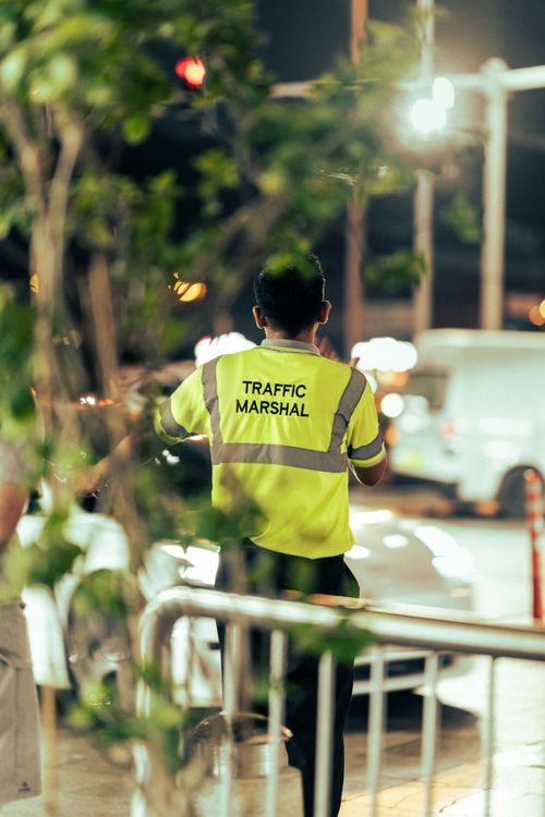 Verkeersregelaar begeleidt verkeer 's avonds bij een evenement