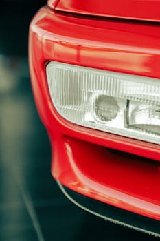 Vertical close-up of a red vintage car headlight, showcasing retro design.