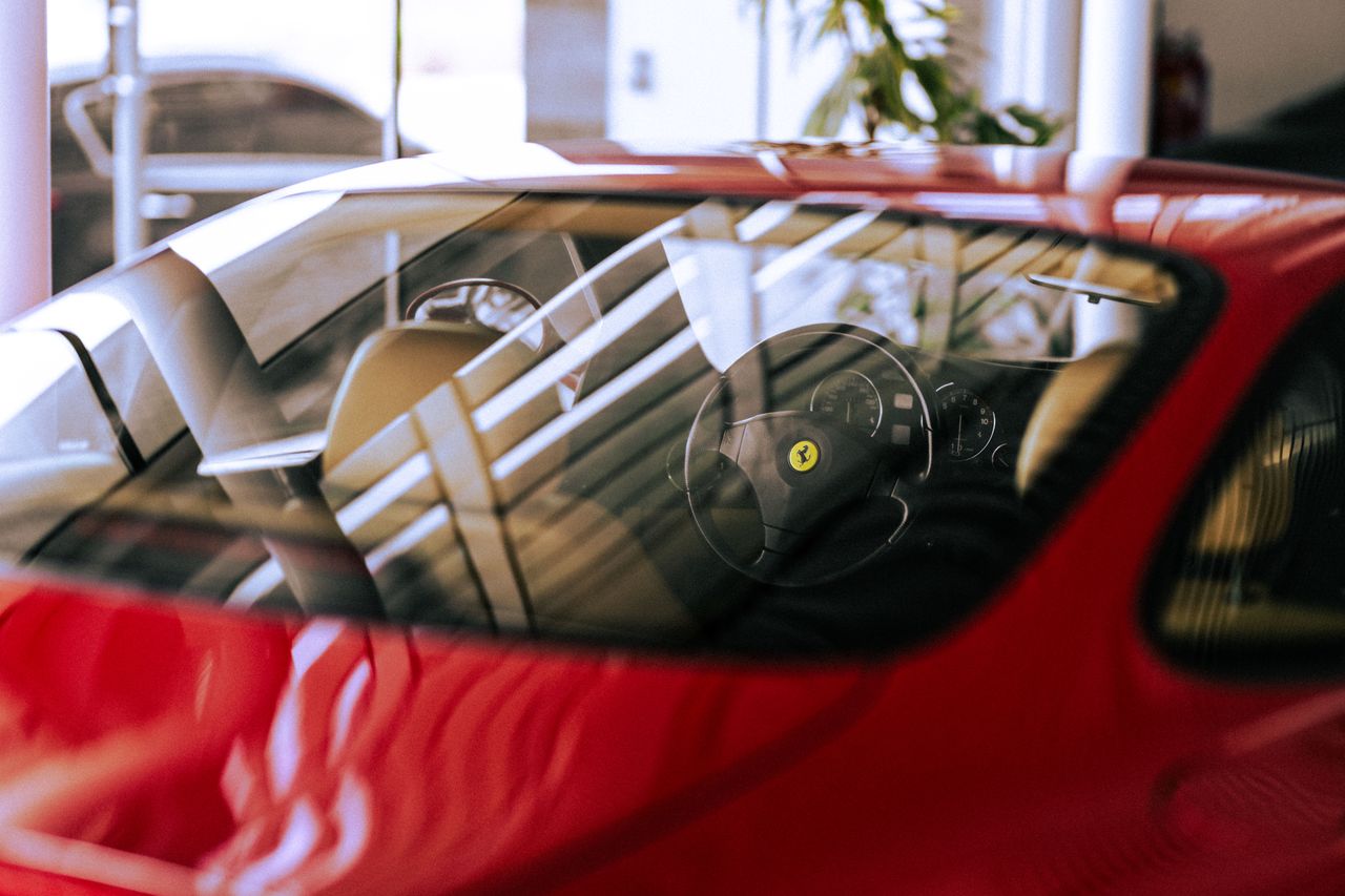 close up of a stylish red ferrari interior with sunlight reflection in