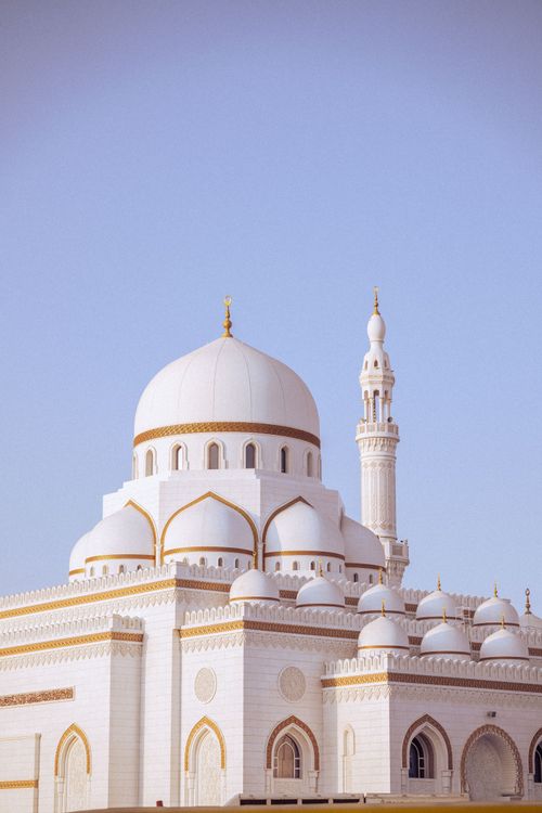 Free A stunning white mosque with a dome and minaret under a clear blue sky in Dubai. Stock Photo