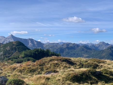A serene mountain landscape with rolling hills under a clear blue sky, perfect for nature lovers.