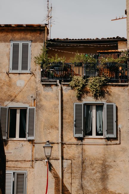A rustic Mediterranean building facade with charming balconies and shutters, capturing urban charm.