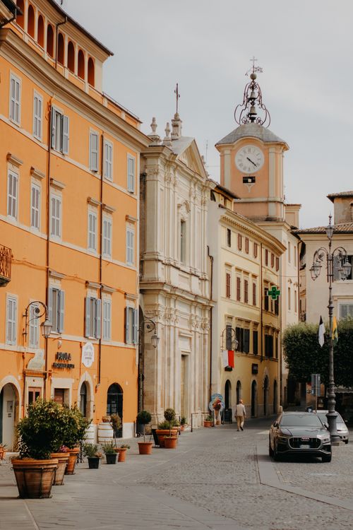 Free A picturesque street in Italy featuring historic buildings and a clock tower, perfect for travel imagery. Stock Photo