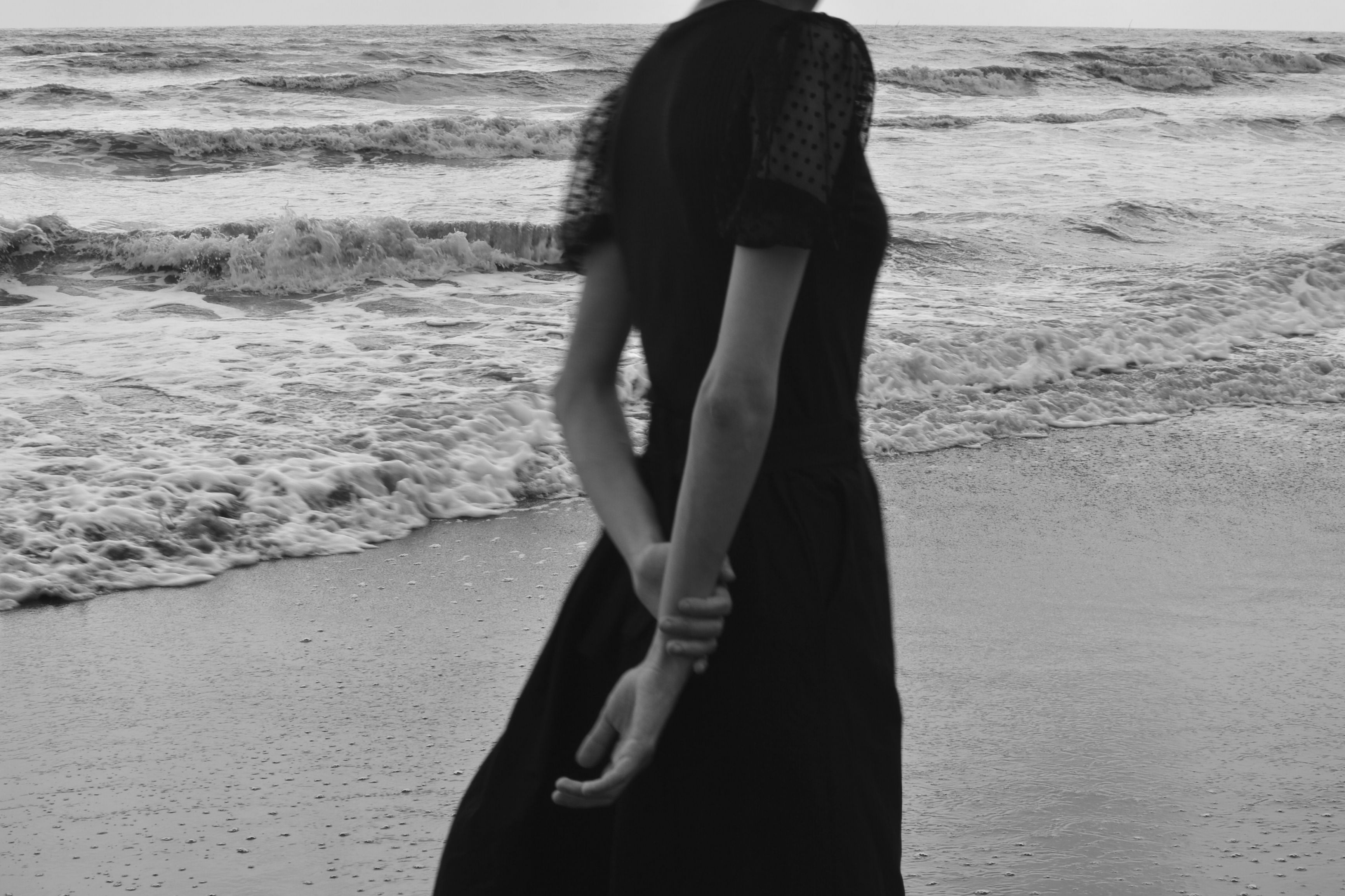 Black and White Photo of a Woman Standing on a Beach · Free Stock Photo