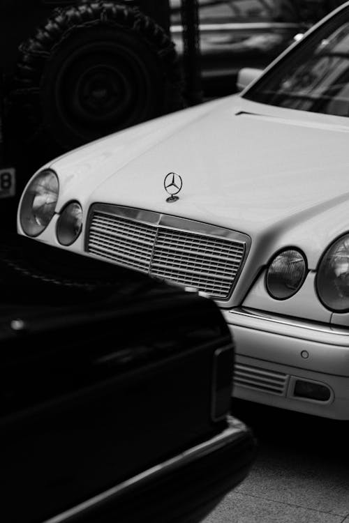 A black and white photo of a white mercedes