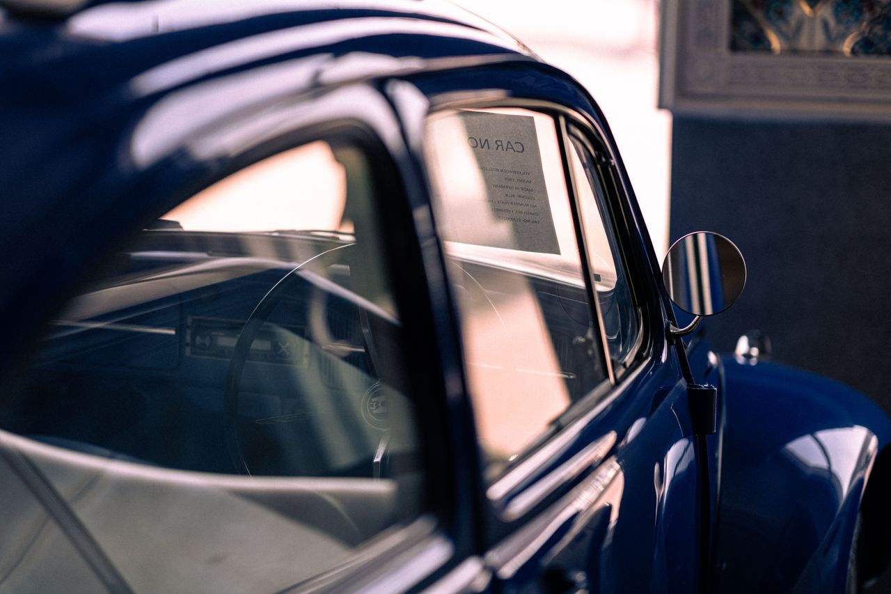 a classic blue vintage car with reflections capturing an elegant retro
