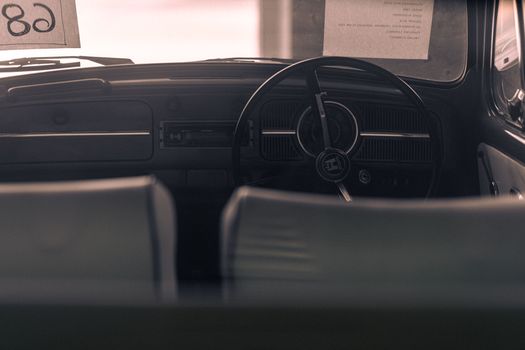 Interior view of a vintage car showcasing the classic dashboard and steering wheel.