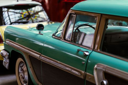 Free Close-up view of a vintage classic car at an indoor car show, showcasing retro design and details. Stock Photo