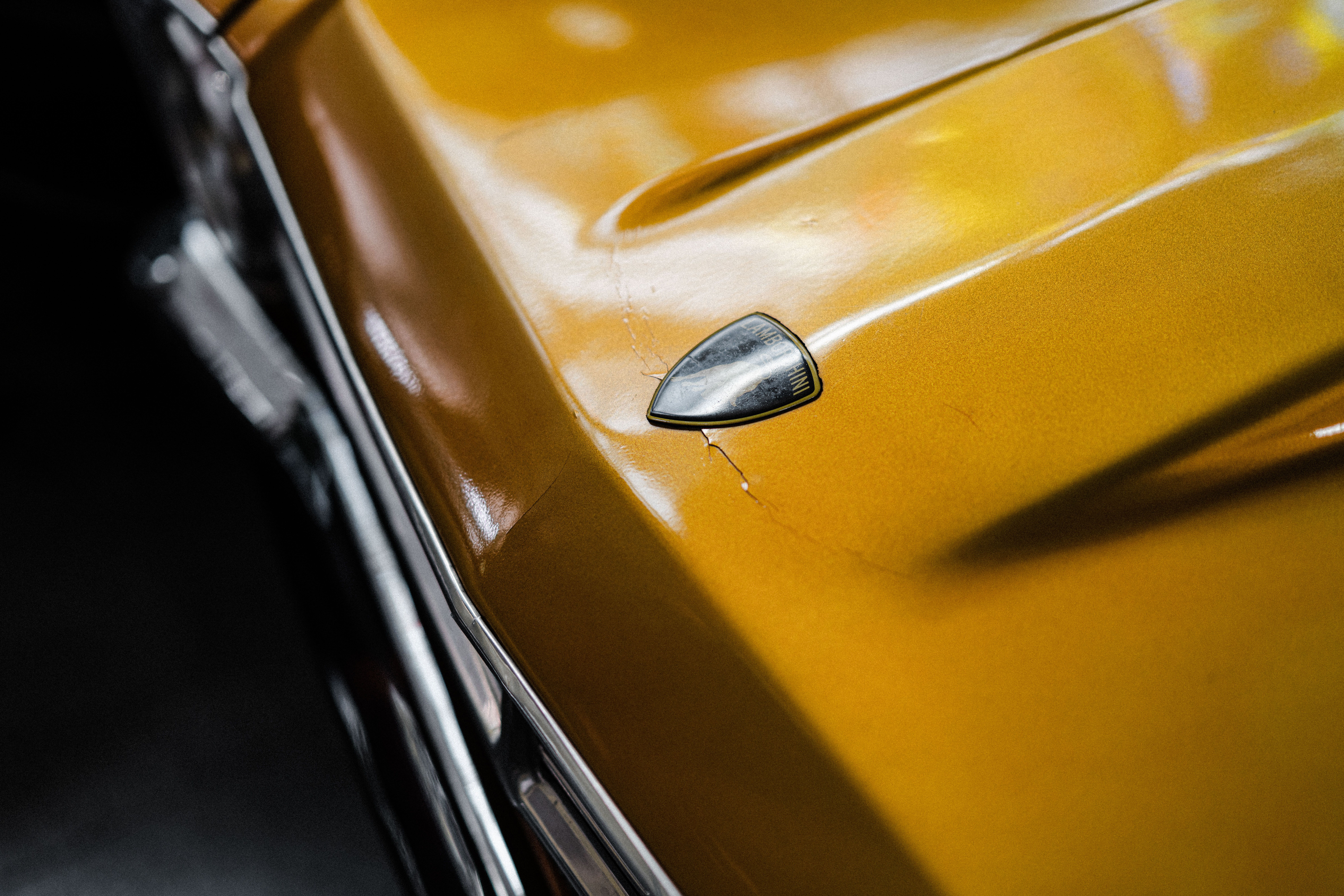 A close up of the hood of a yellow ca