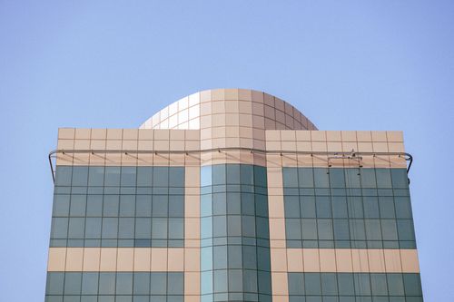 Free A sleek modern building facade set against a clear blue sky, showcasing minimalist architecture. Stock Photo