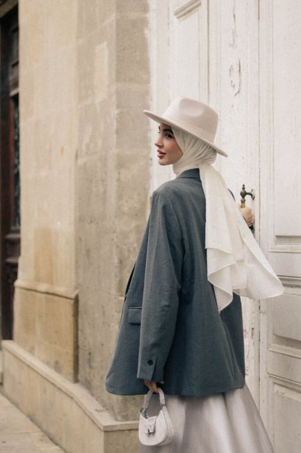 Young woman in chic urban attire posing stylishly on a city street.