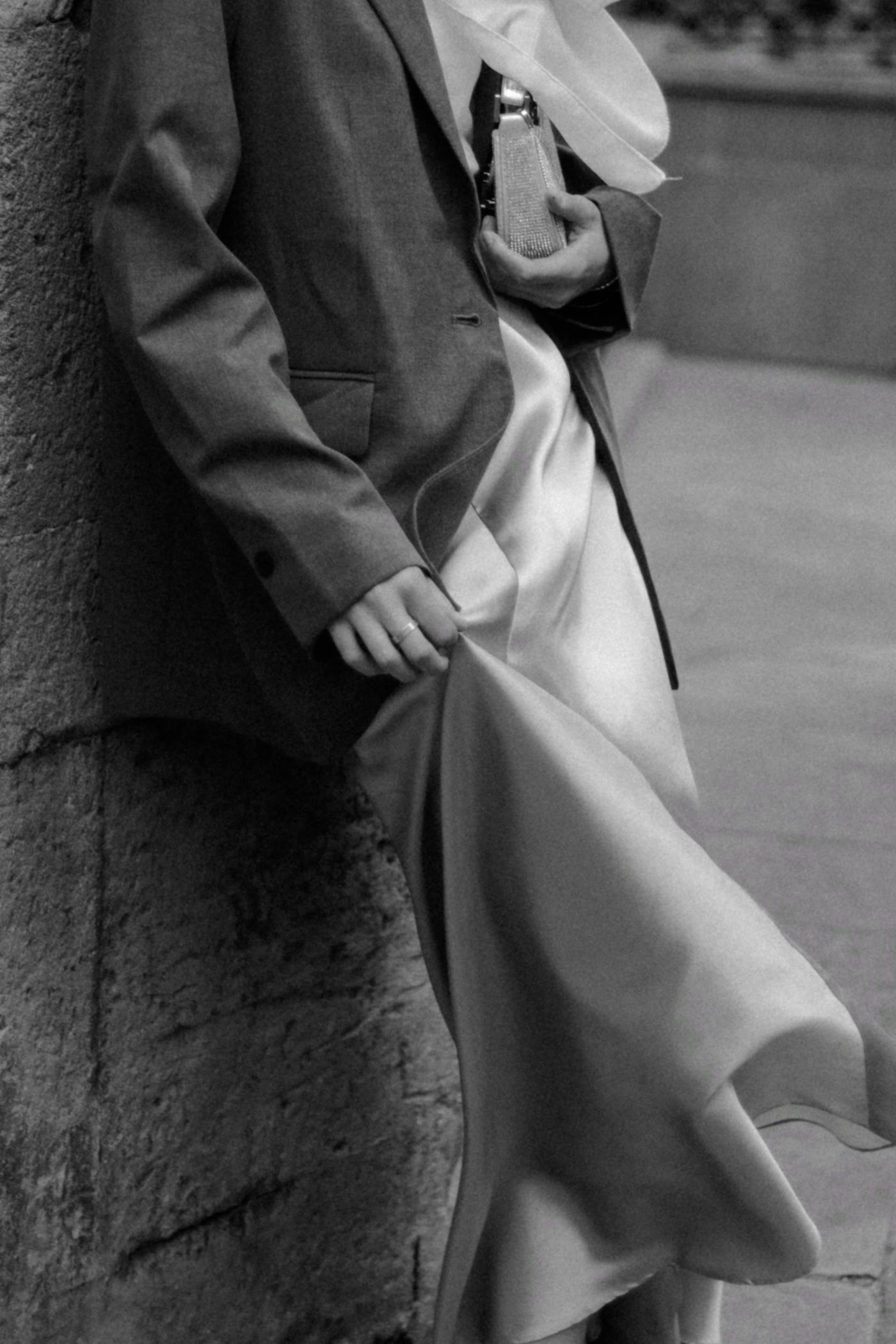 A black and white photo of a woman posing in a blazer and maxi dress — the blazer over everything