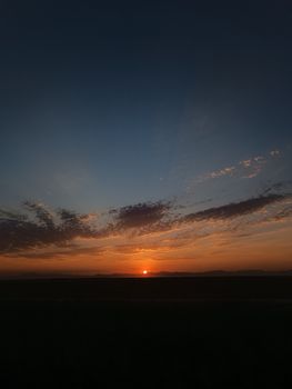 A breathtaking sunset with vivid colors and scattered clouds, creating a serene atmosphere.