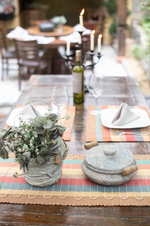無料 テーブルの上に蓋付きの調理鍋の横にある花瓶の緑の葉の植物 写真素材