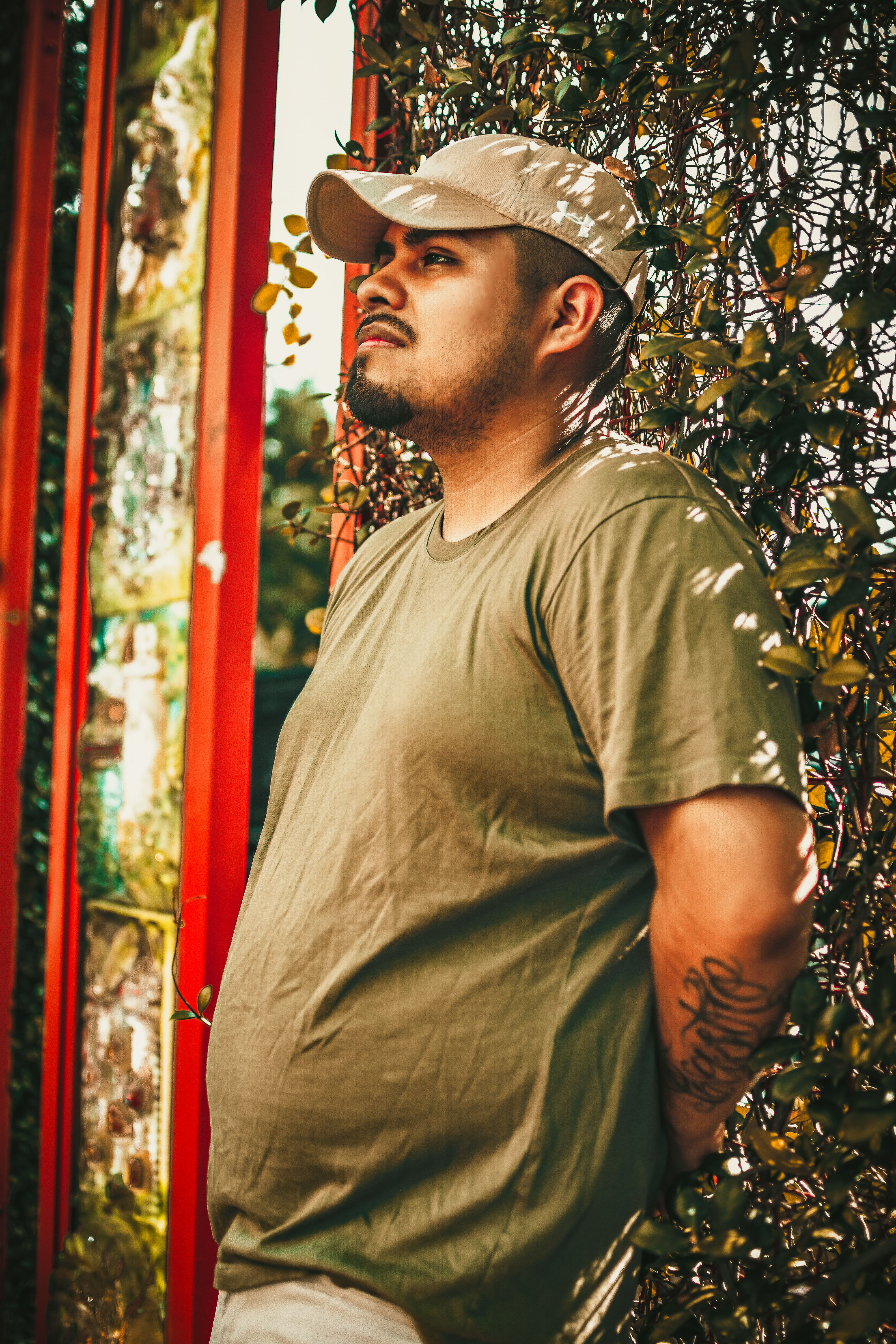 Man in casual wear standing calmly in a garden in Tampa, FL with summer vibes.