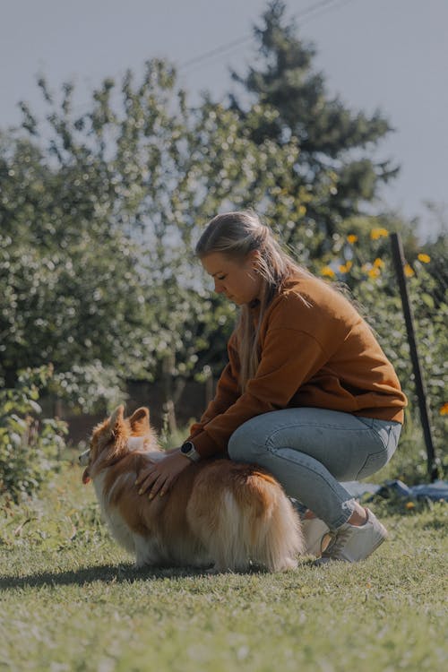 Woman Petting her Welsh Corgi