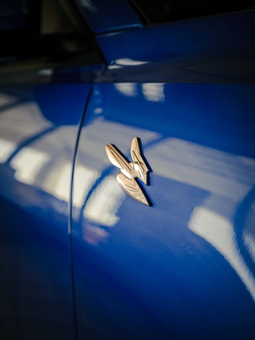 Free Detailed shot of a blue car's metallic emblem, showcasing design and color. Stock Photo