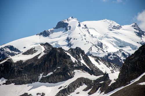 Free A stunning view of snow-capped mountain peaks against a clear blue sky. Stock Photo