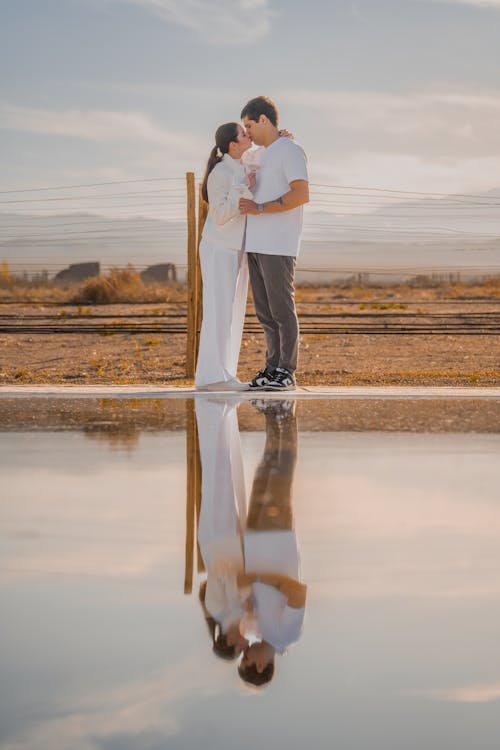 Woman and Man Standing and Kissing by Water