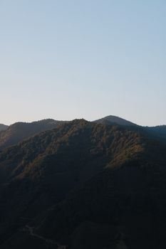 A breathtaking view of a mountain landscape at sunrise with subtle shadows and steep slopes.